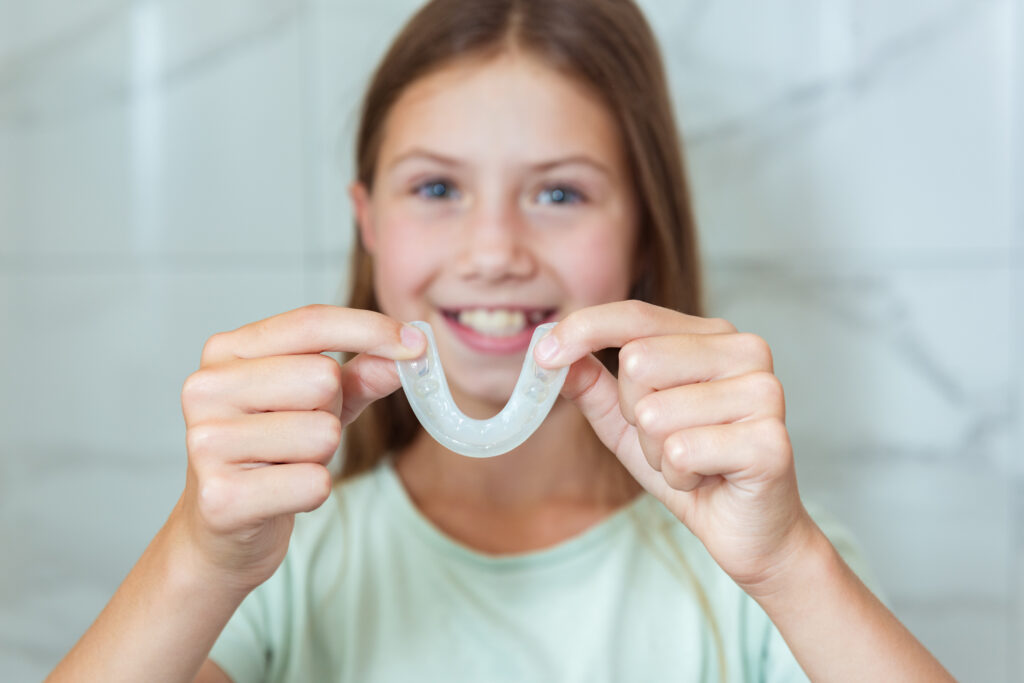 インビザライン・ファーストのマウスピースを持つ女の子