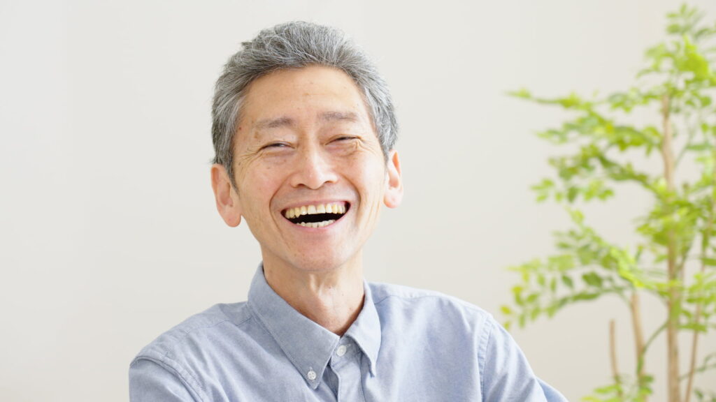 前歯の入れ歯を入れている笑顔の男性