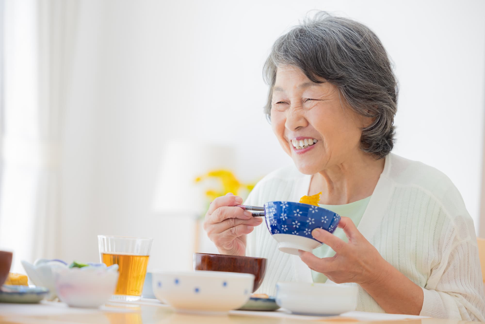 インプラント治療をして快適に食事をする女性