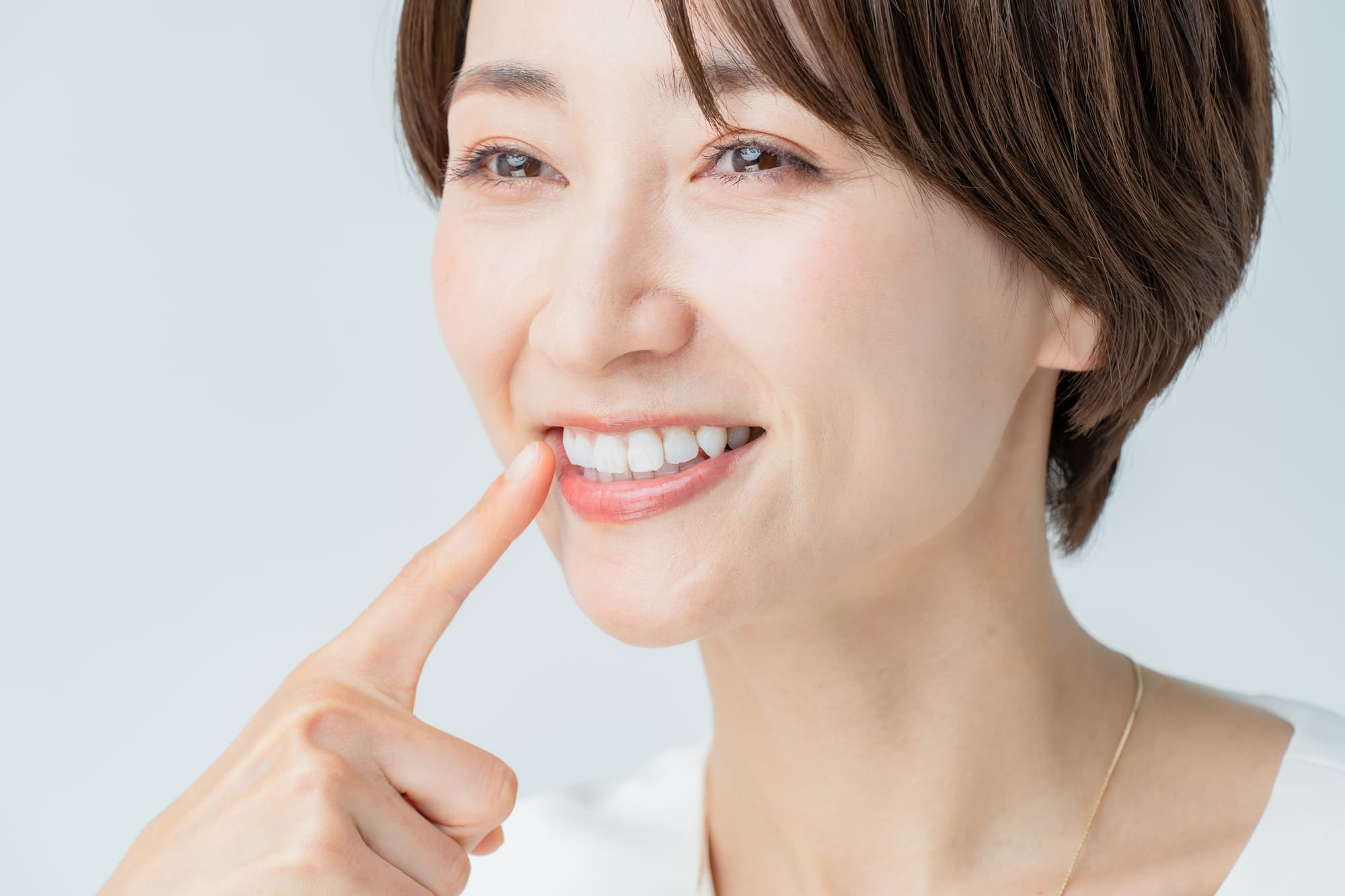 セラミックの歯を指さす女性