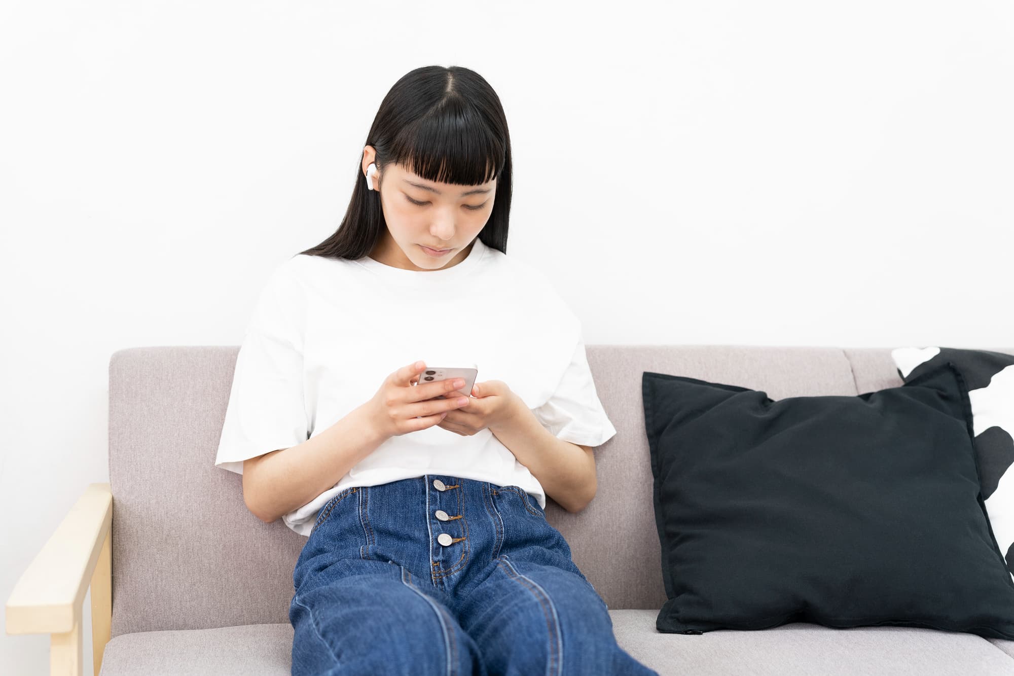 長時間のスマートフォン操作で下を向く女性