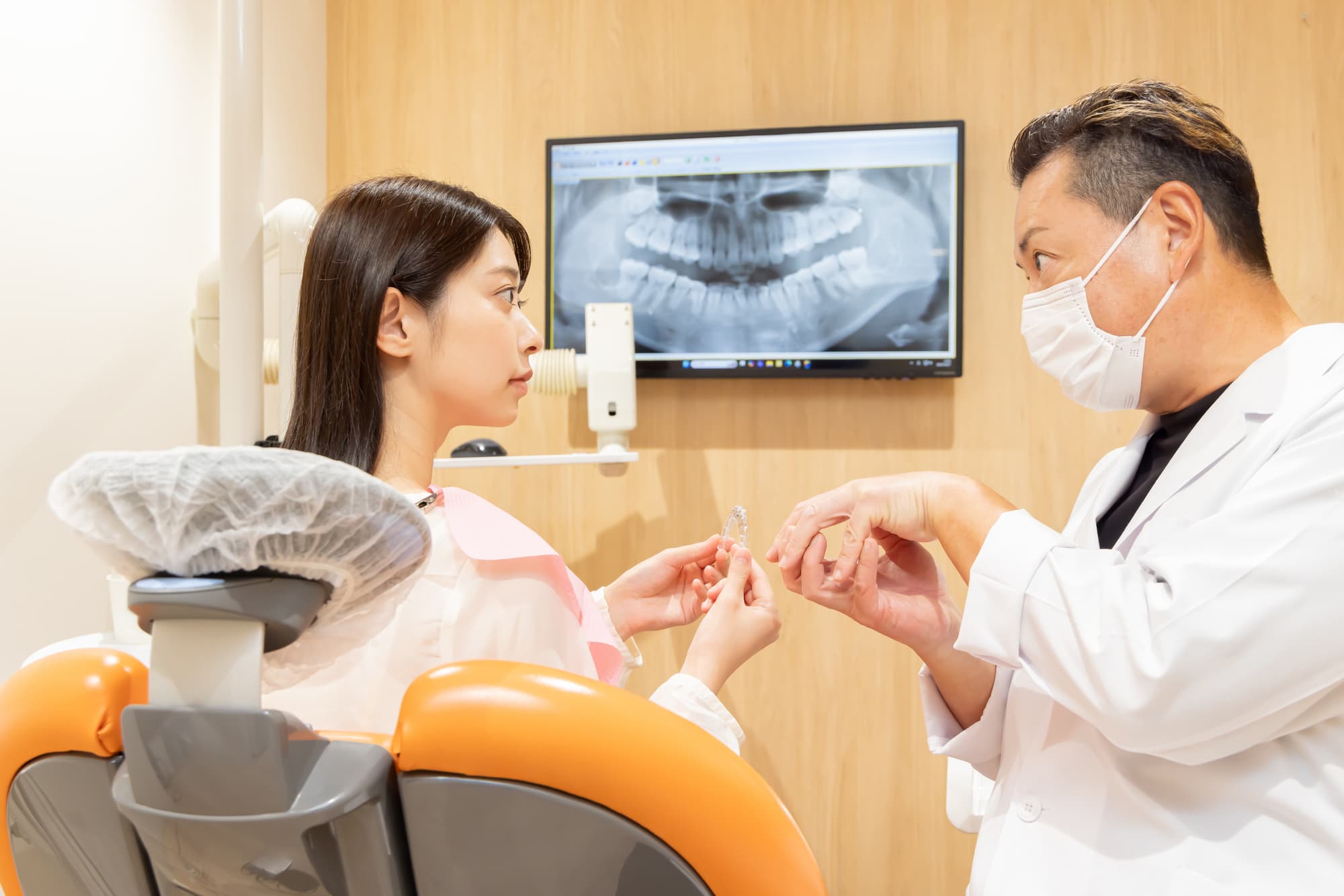 マウスピース矯正中に装置が浮くため歯科医に相談している女性