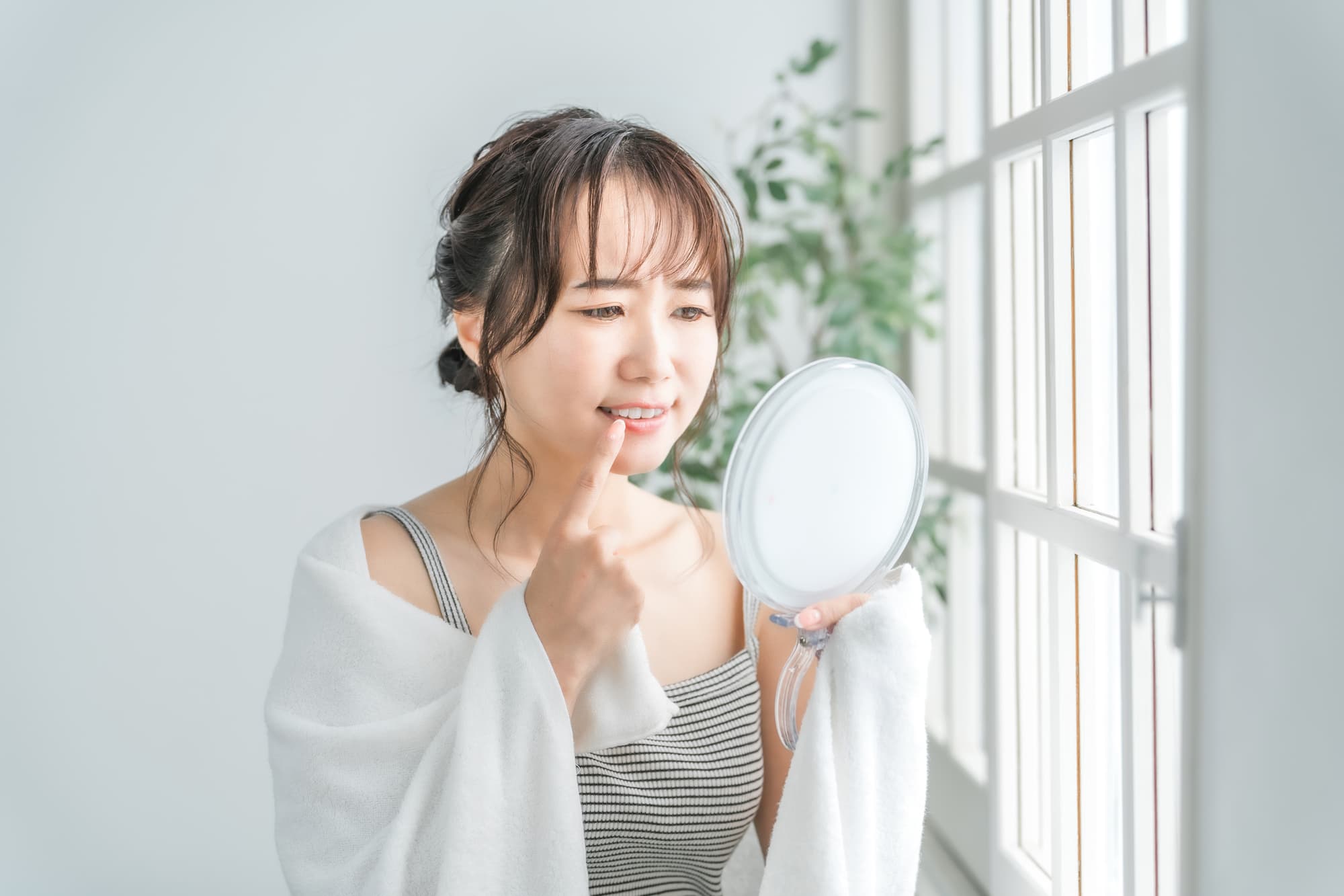 マウスピースが浮いたまま放置した女性が歯に痛みを感じて鏡を見ているイメージ